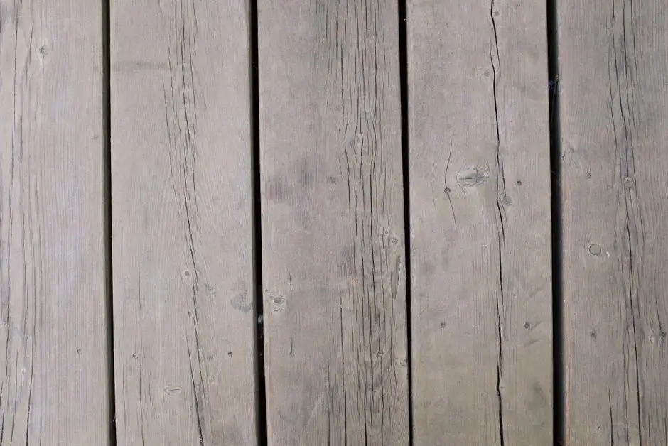 A close-up of weathered gray wood deck boards showing what happens without yearly maintenance