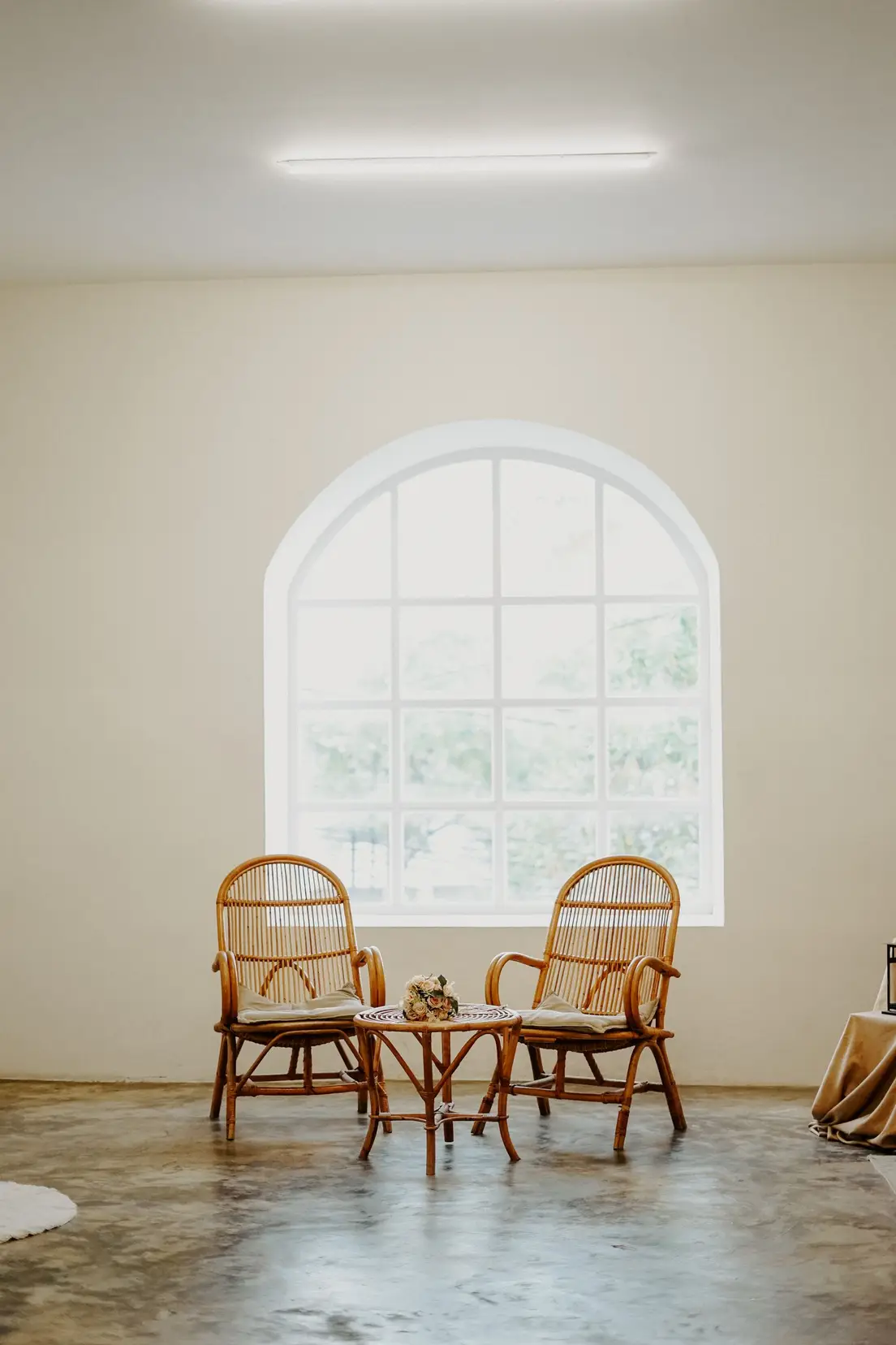 Two matching rattan armchairs and a rattan side table, an example of overusing one material as a set