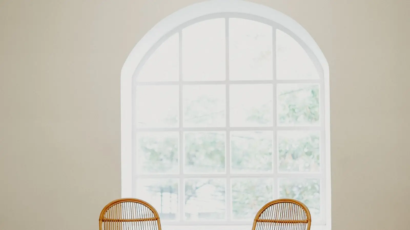 Two matching rattan armchairs and a rattan side table, an example of overusing one material as a set