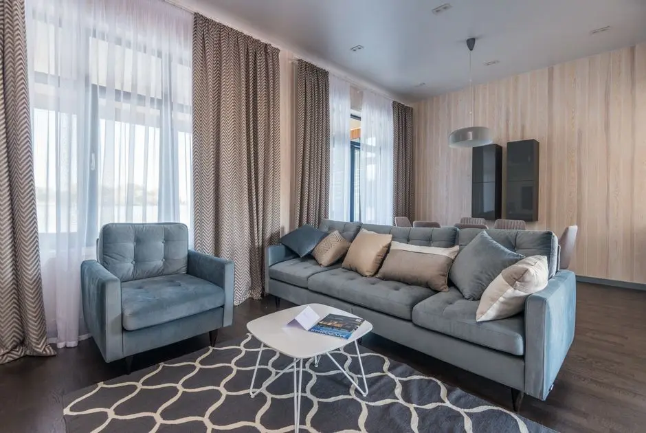 Floor-to-ceiling natural linen curtains in a warm living room, an organic modern window treatment idea