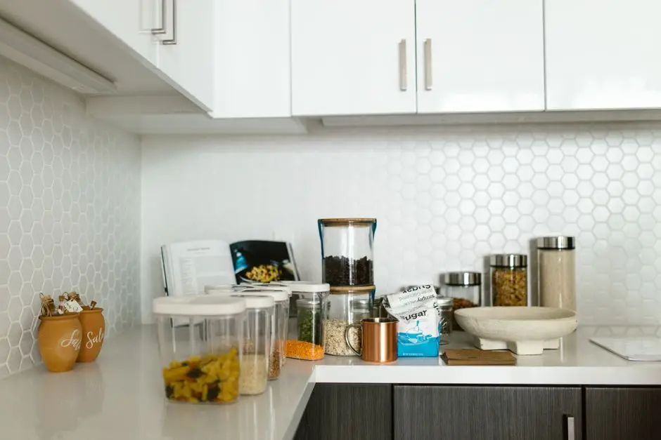 An organized kitchen countertop with labeled glass jars and pantry containers