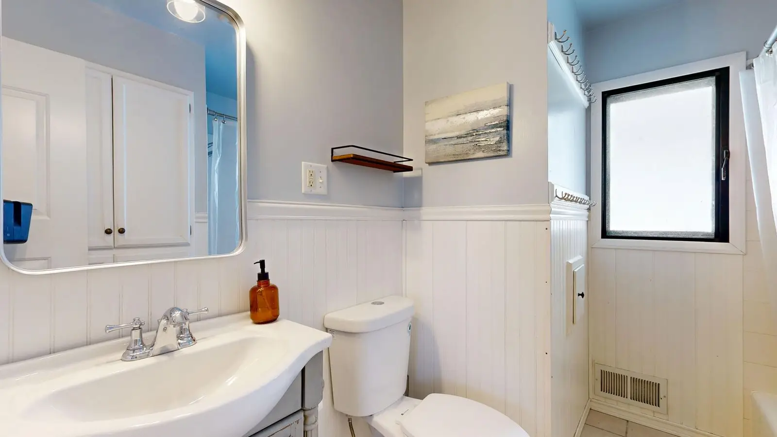A small half bathroom with a pale blue painted ceiling and white walls
