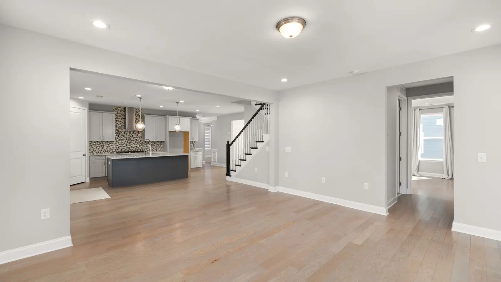 A small home with the same warm flooring and wall color carried from the kitchen through to the living room