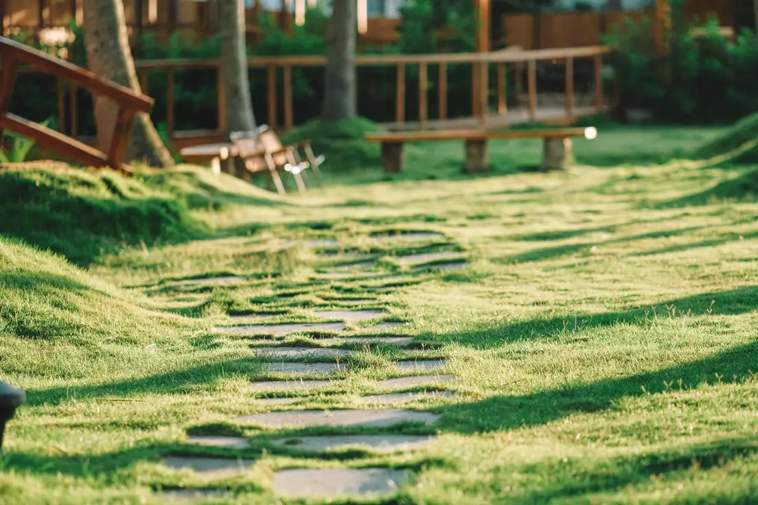 A stepping-stone paver path leading across a grass lawn