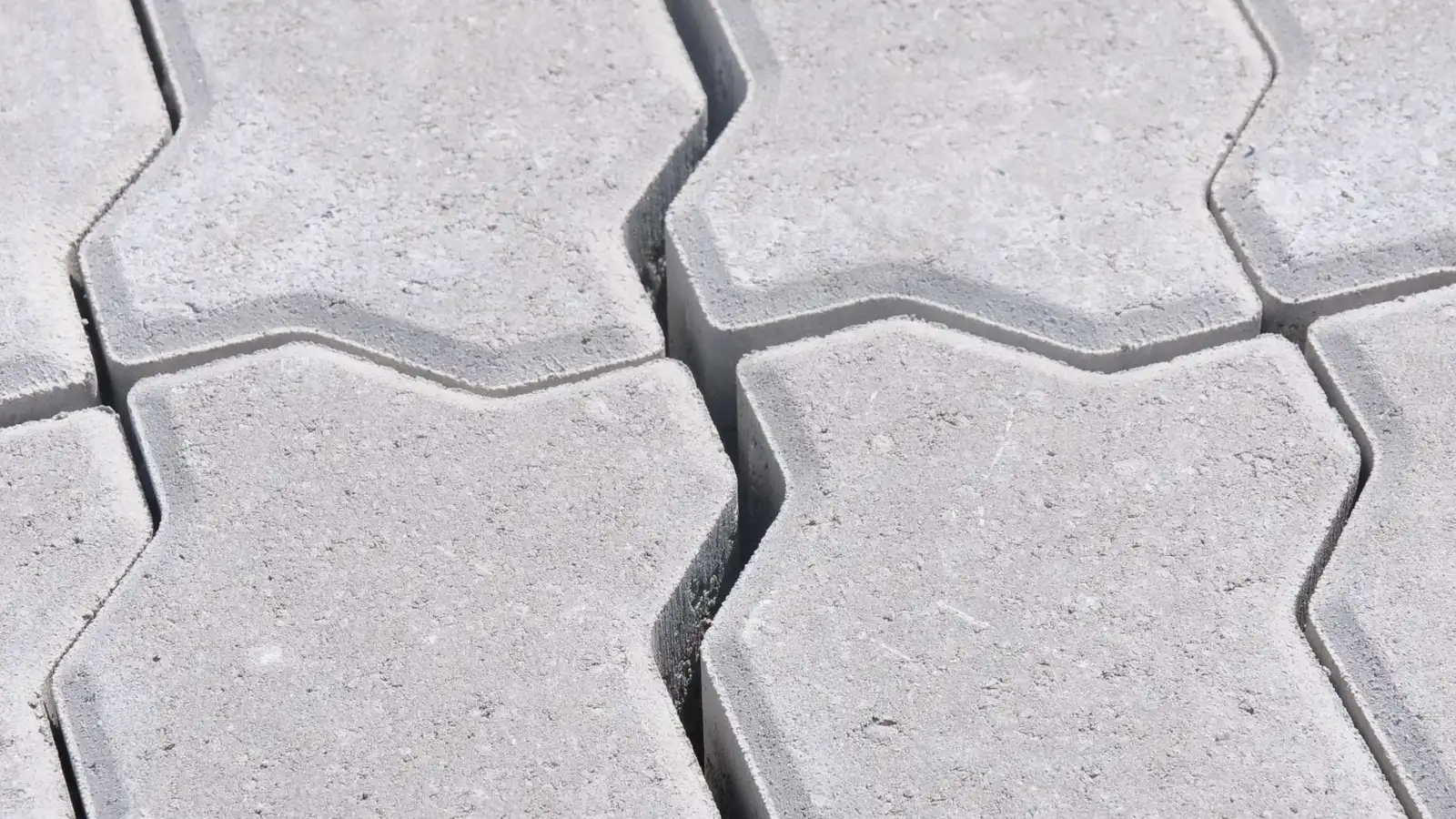 Close-up of gray interlocking concrete pavers laid in a herringbone pattern