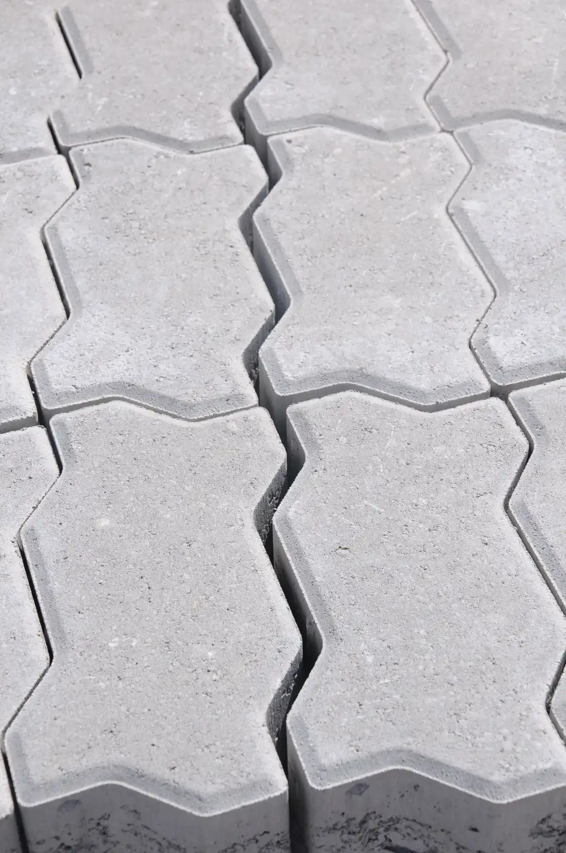 Close-up of gray interlocking concrete pavers laid in a herringbone pattern