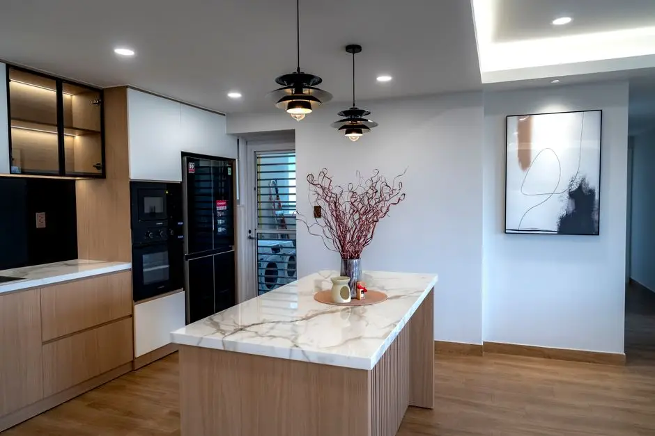 Two black pendant lights hanging over a small kitchen island