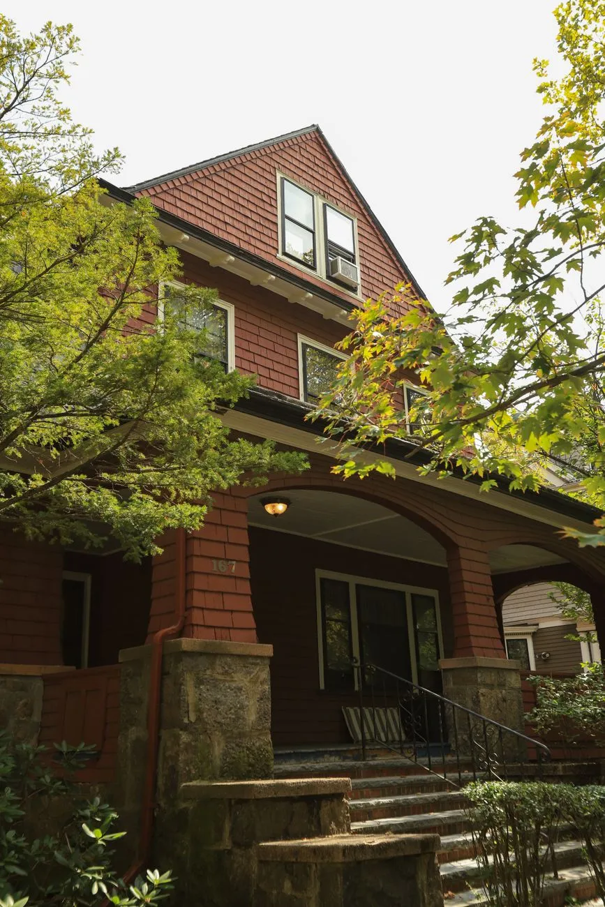 A craftsman-style house porch with a stone base and covered entry