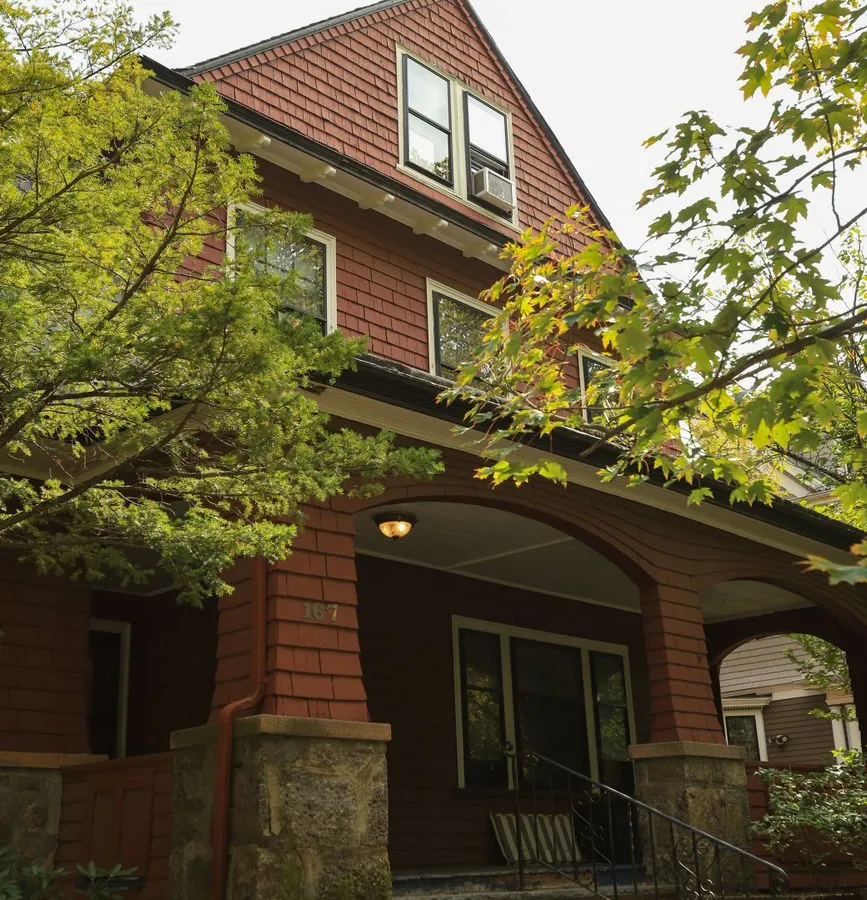 A craftsman-style house porch with a stone base and covered entry