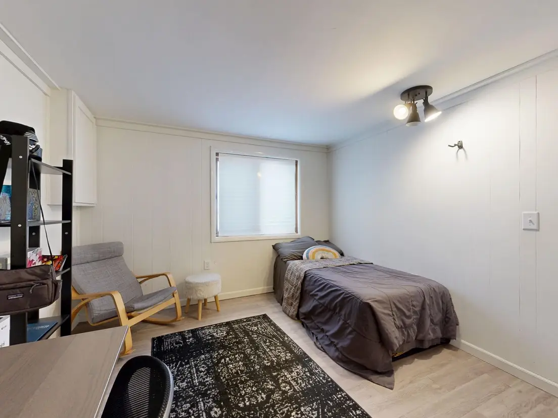 An area rug sized to the walkway around the bed in a small primary bedroom