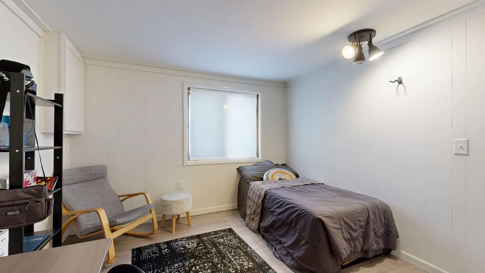 An area rug sized to the walkway around the bed in a small primary bedroom