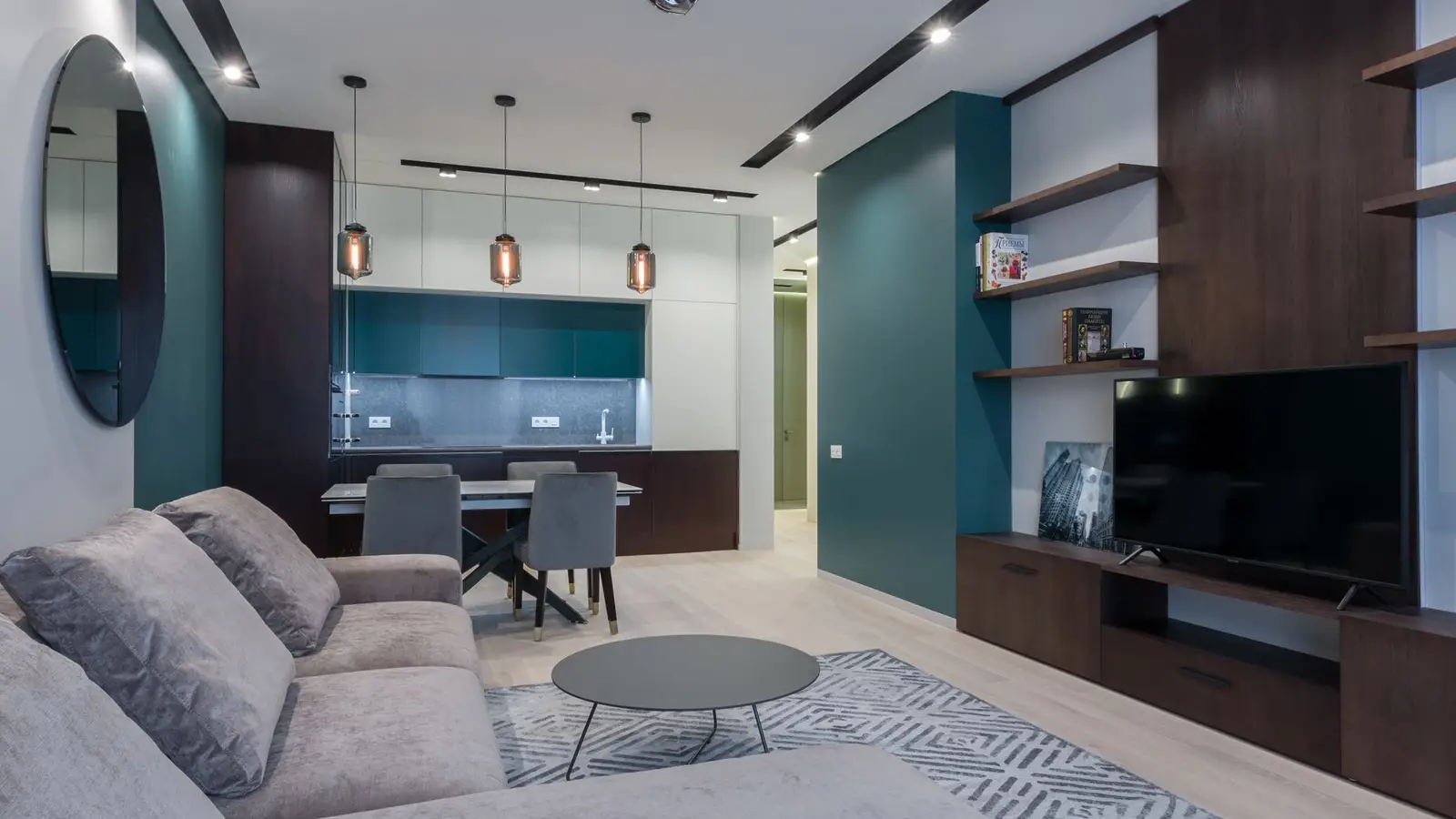 A large neutral area rug zoning the living room seating area next to an open kitchen