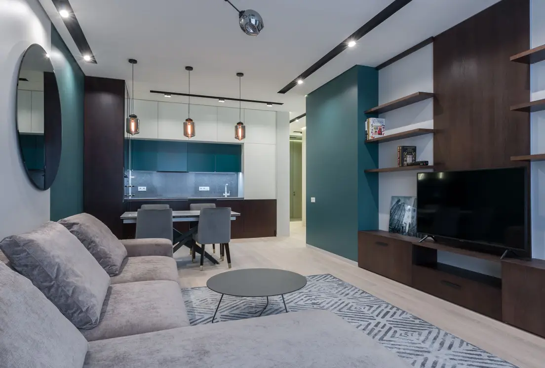 A large neutral area rug zoning the living room seating area next to an open kitchen