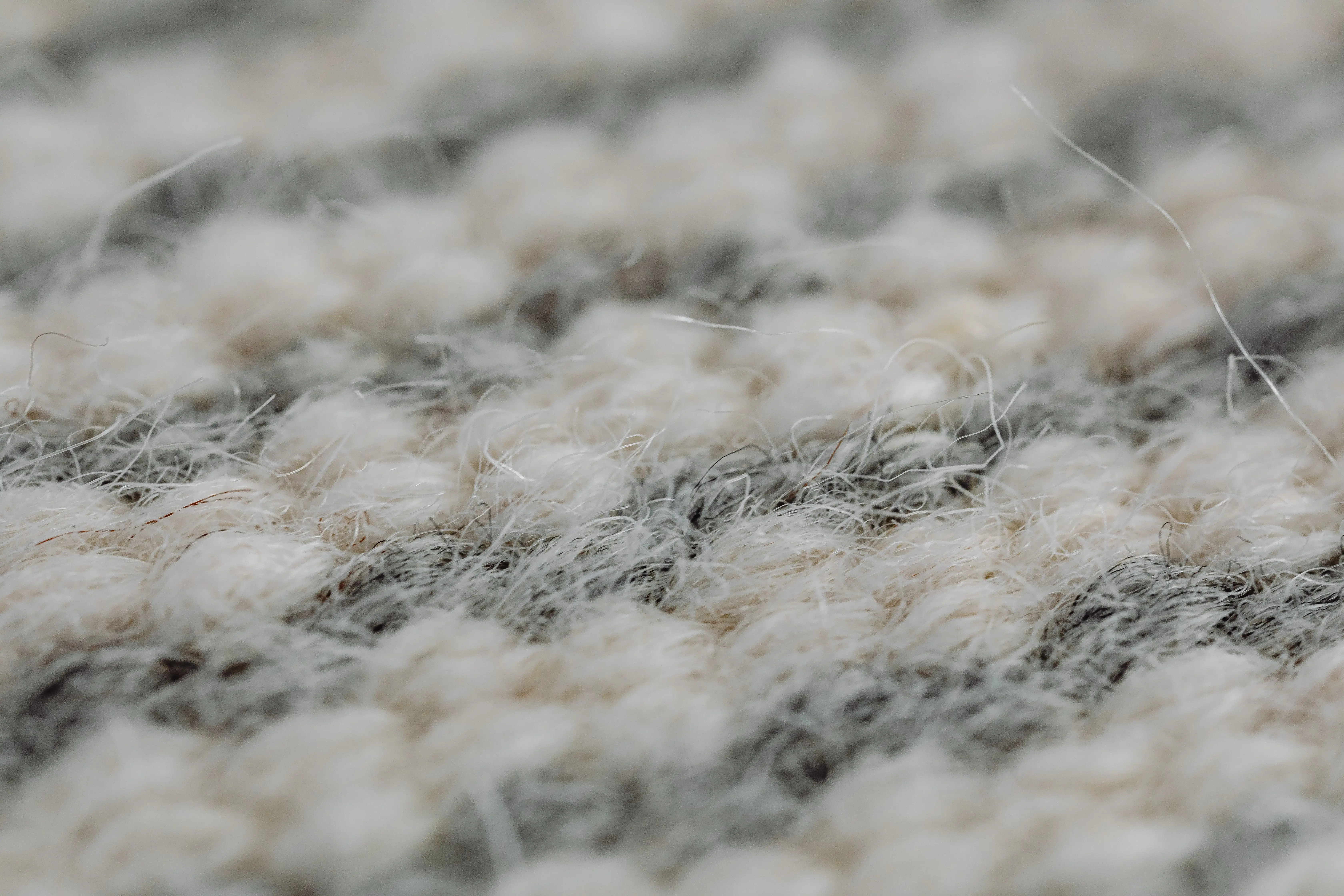 A close-up of a neutral wool area rug texture for a Japandi living room floor