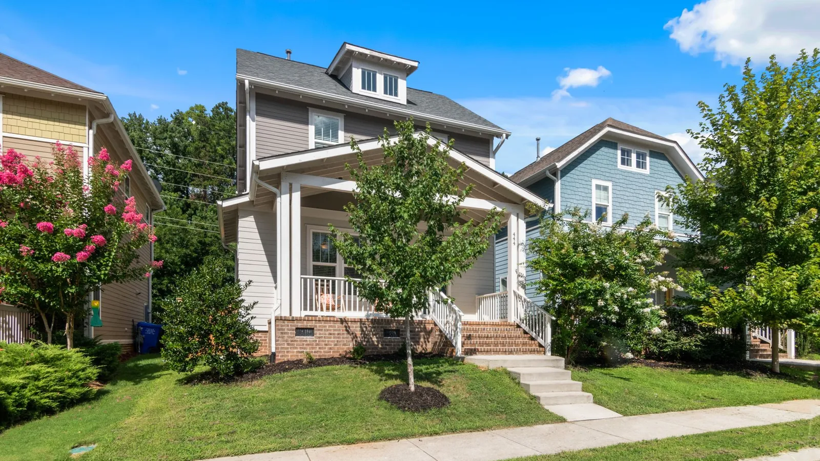 A finished craftsman-style house exterior with a covered porch and consistent white trim