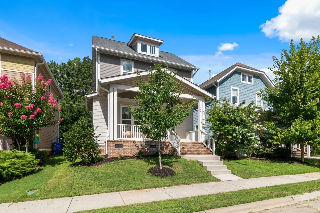 A finished craftsman-style house exterior with a covered porch and consistent white trim