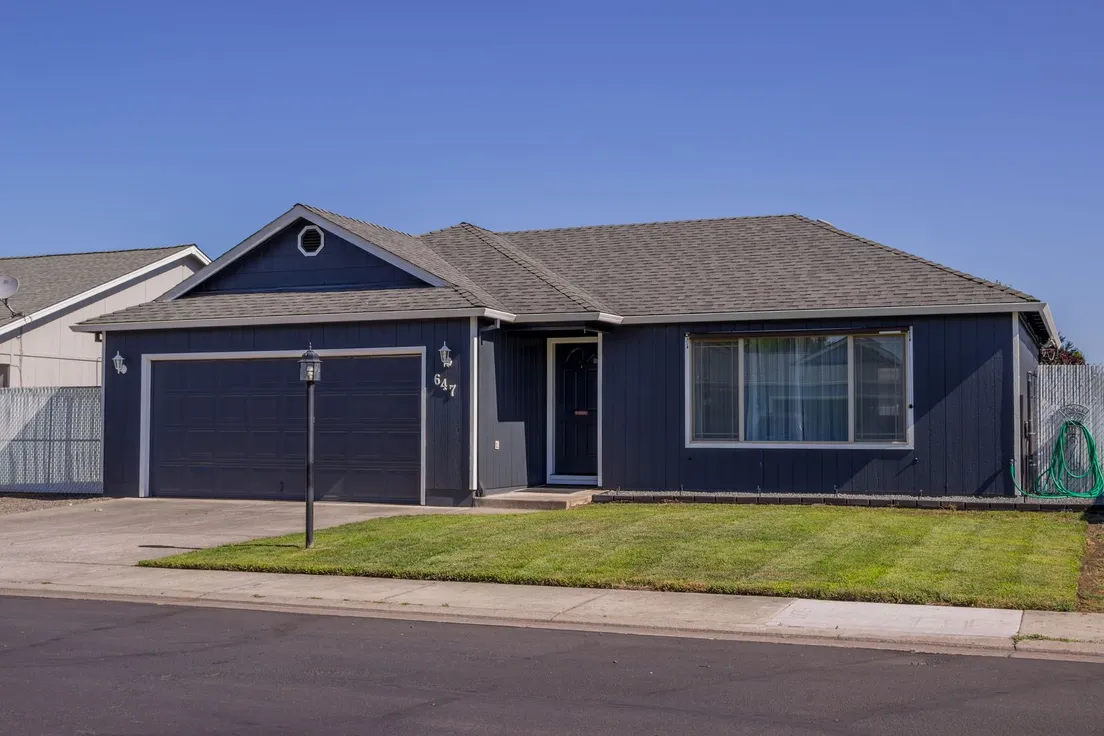 A navy single-story ranch house with a red front door, an example of finished curb appeal