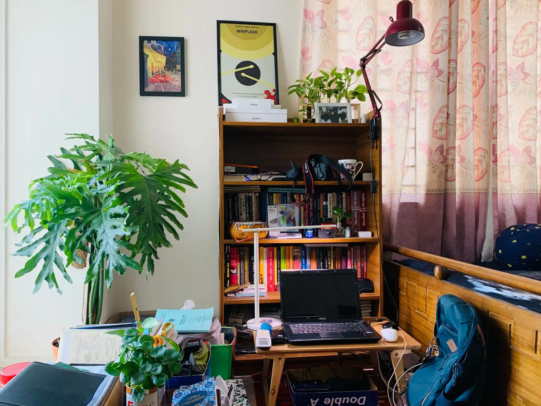 A wooden hutch desk with a bookshelf above and a laptop on the writing surface, a desk and bookshelf combo in a living room