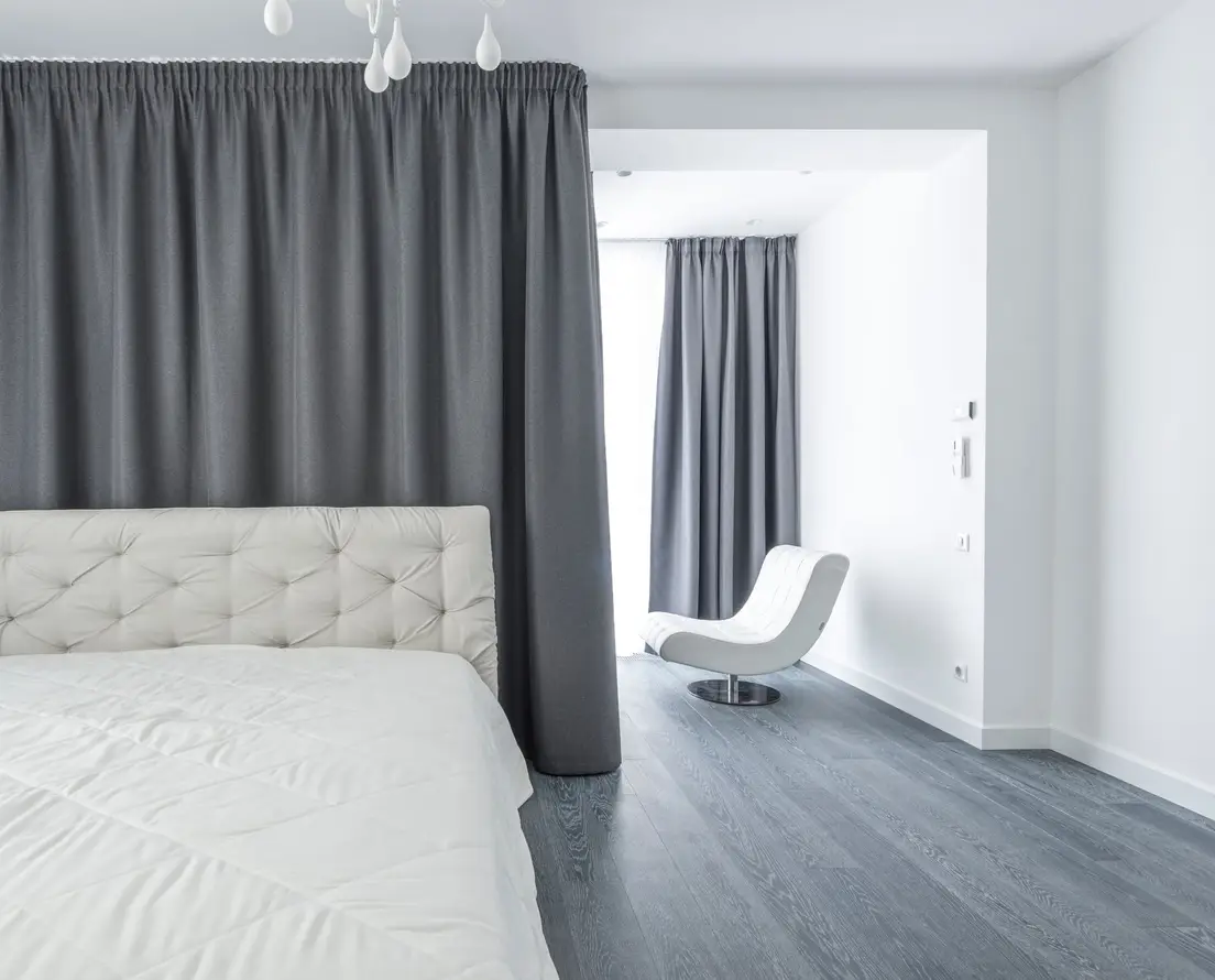 A sleeping nook in a small apartment curtained off from the rest of the studio for privacy