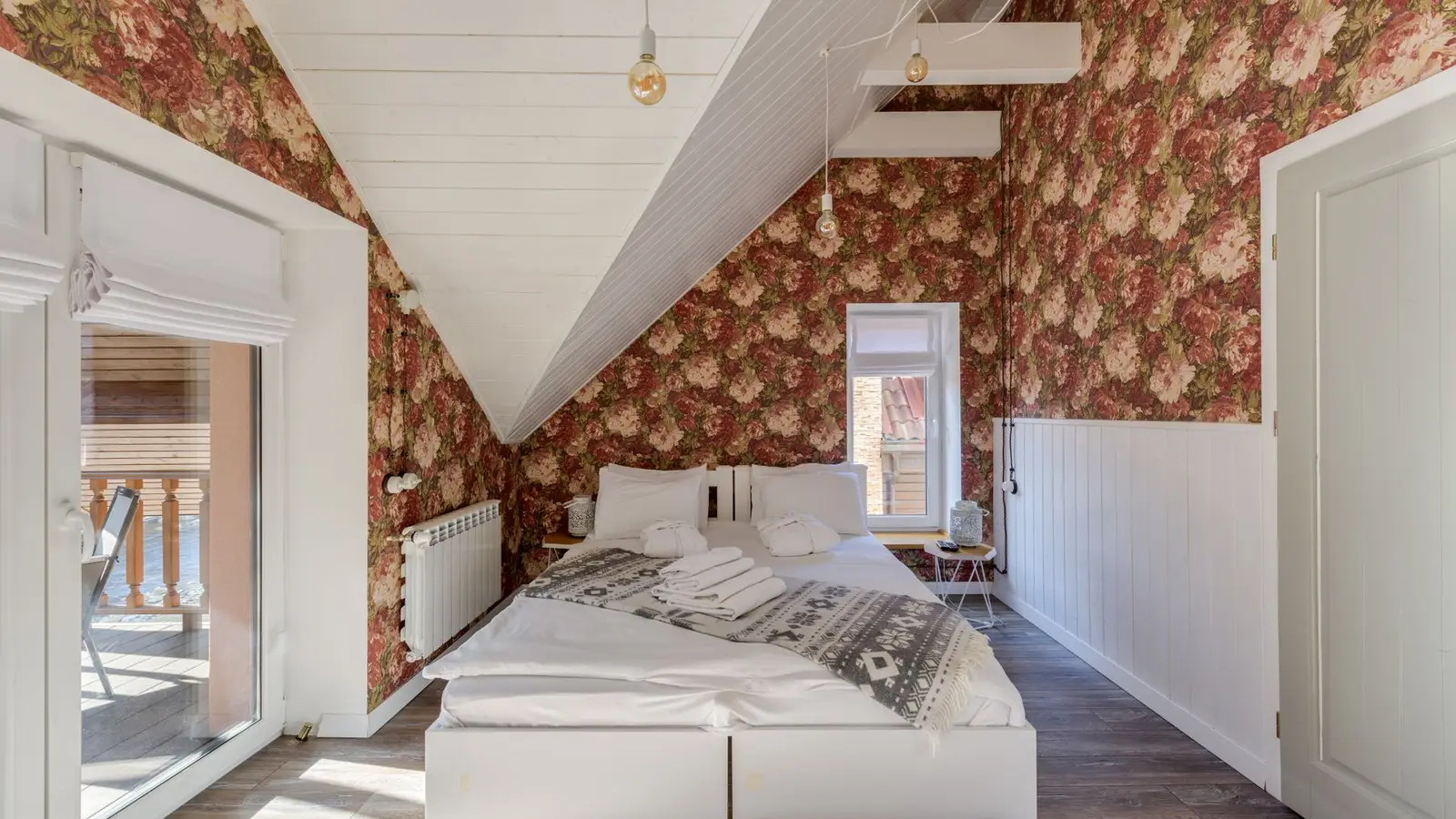 A primary bedroom with a sloped attic ceiling and furniture kept off the lowest wall