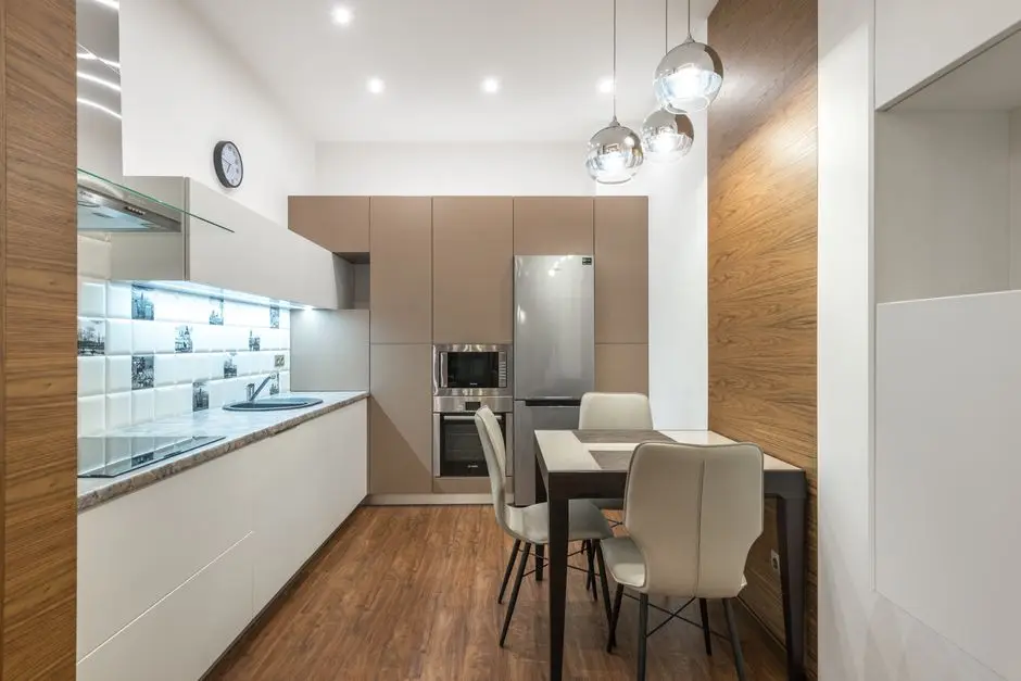A small closed kitchen layout with light cabinetry and under-cabinet lighting