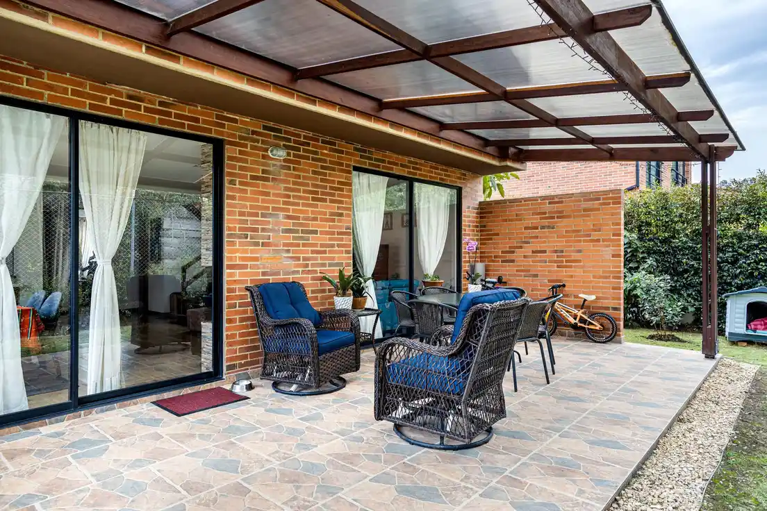 A translucent polycarbonate solid roof over a patio seating area