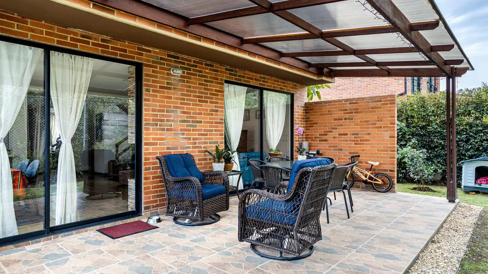A translucent polycarbonate solid roof over a patio seating area