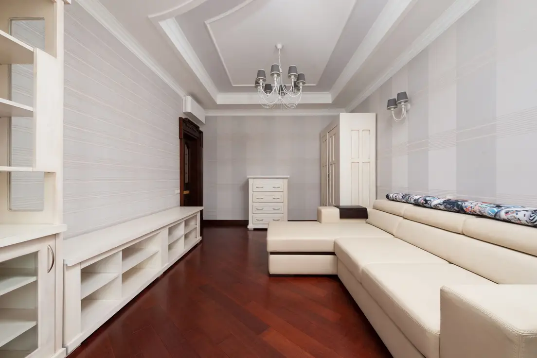 A cream sectional sofa with a separable chaise piece styled as two furniture pieces