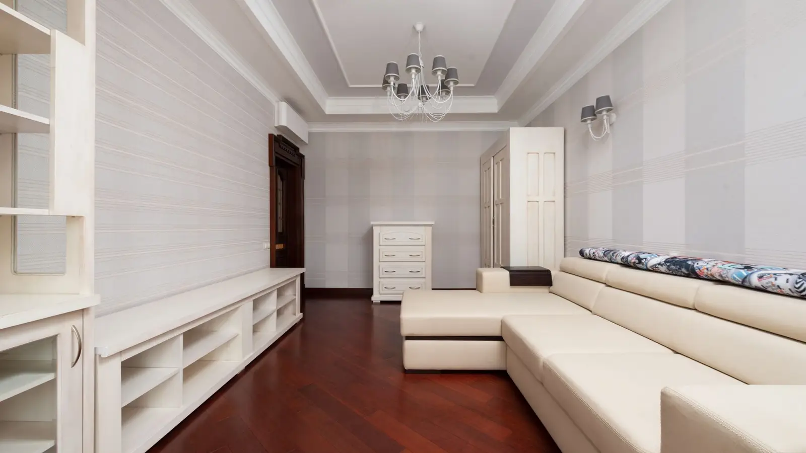 A cream sectional sofa with a separable chaise piece styled as two furniture pieces