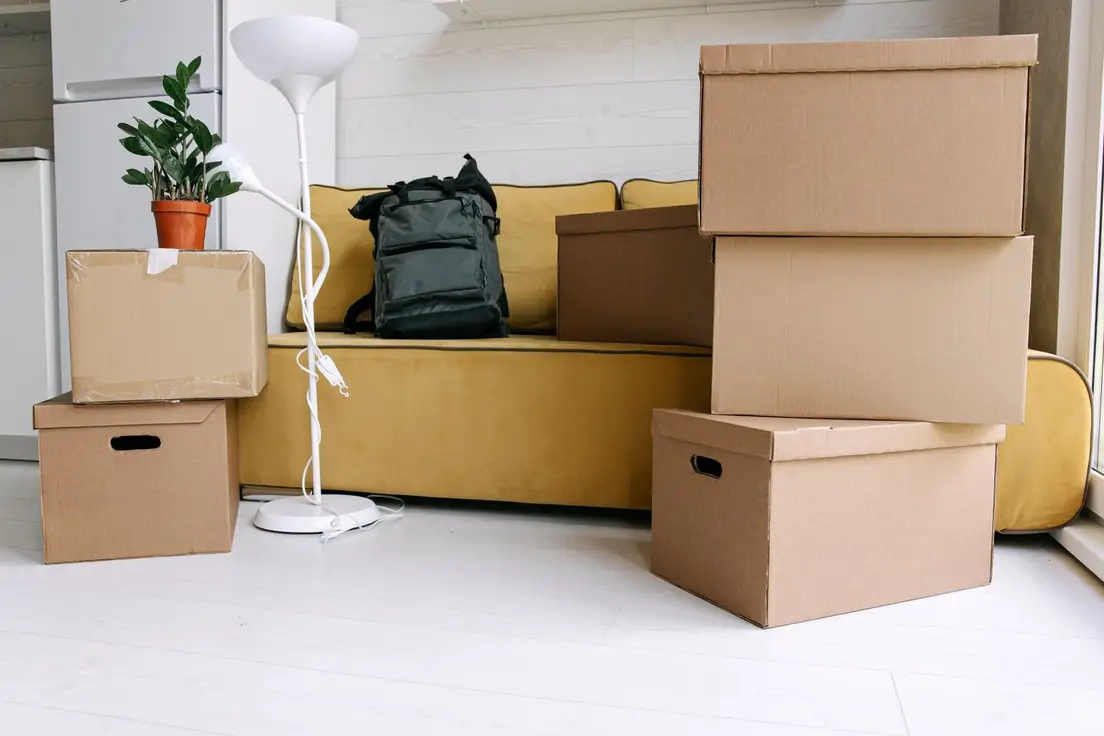 Moving boxes stacked in an apartment living room, illustrating taking down a temporary wall before moving out