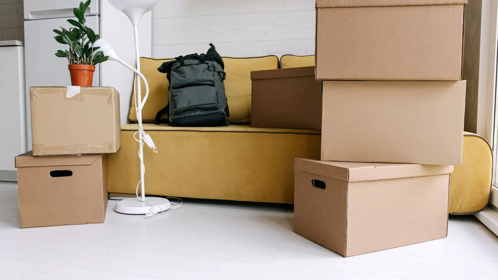 Moving boxes stacked in an apartment living room, illustrating taking down a temporary wall before moving out