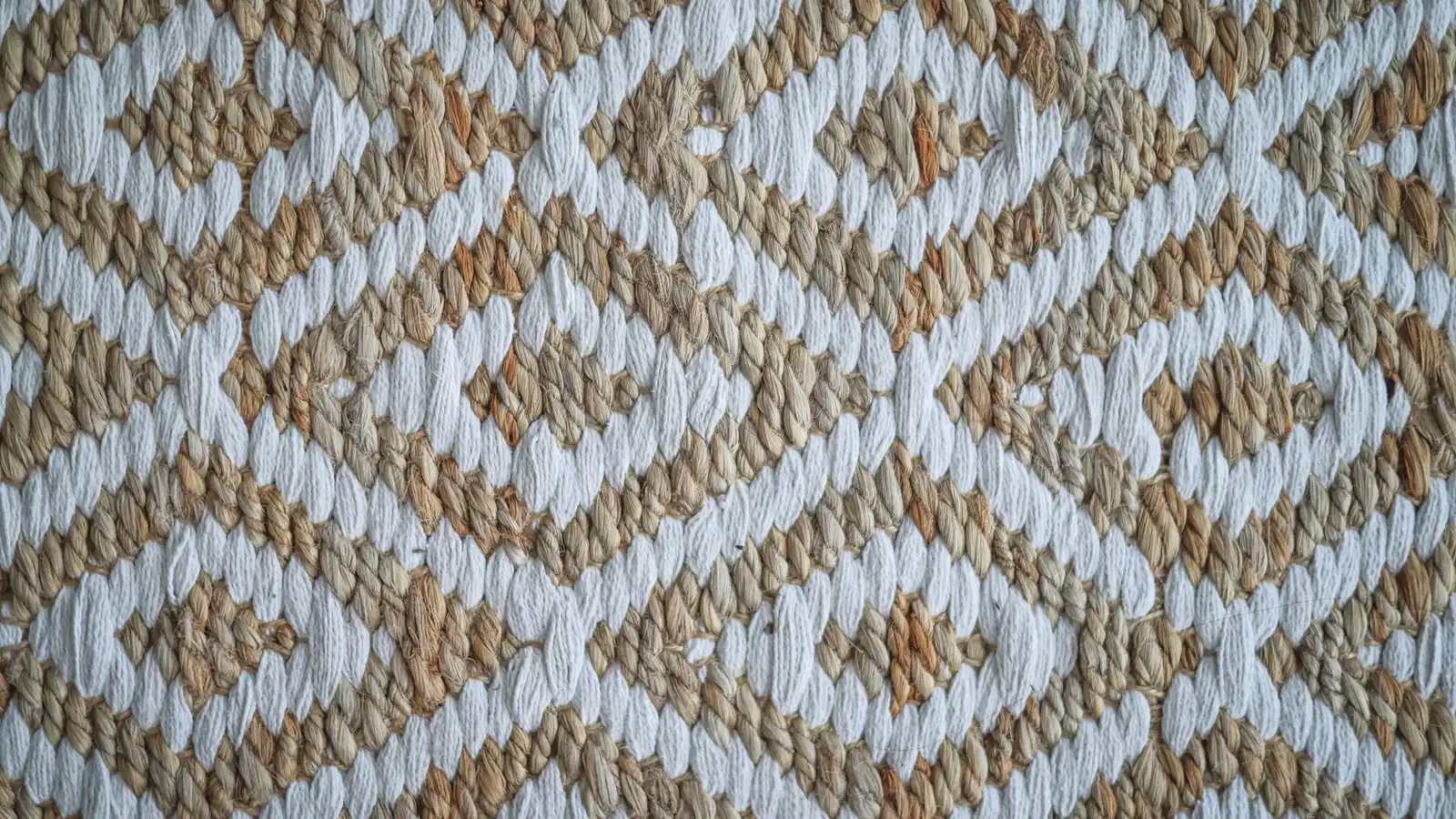 Close-up of a woven jute and cotton rug in a warm tan and cream diamond pattern
