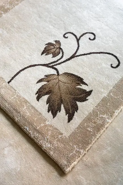 Close-up of a textured wool area rug with a natural leaf motif for organic modern living room decor