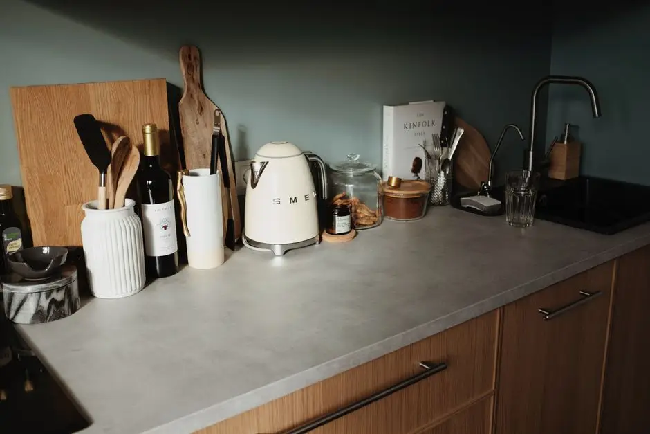 A styled kitchen counter at night with a kettle, cutting boards, and a few items left out