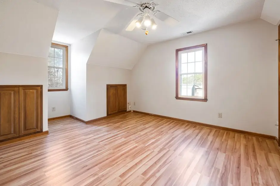 An empty bedroom with white window and door trim against light walls, showing how trim color frames the best bedroom wall color choice