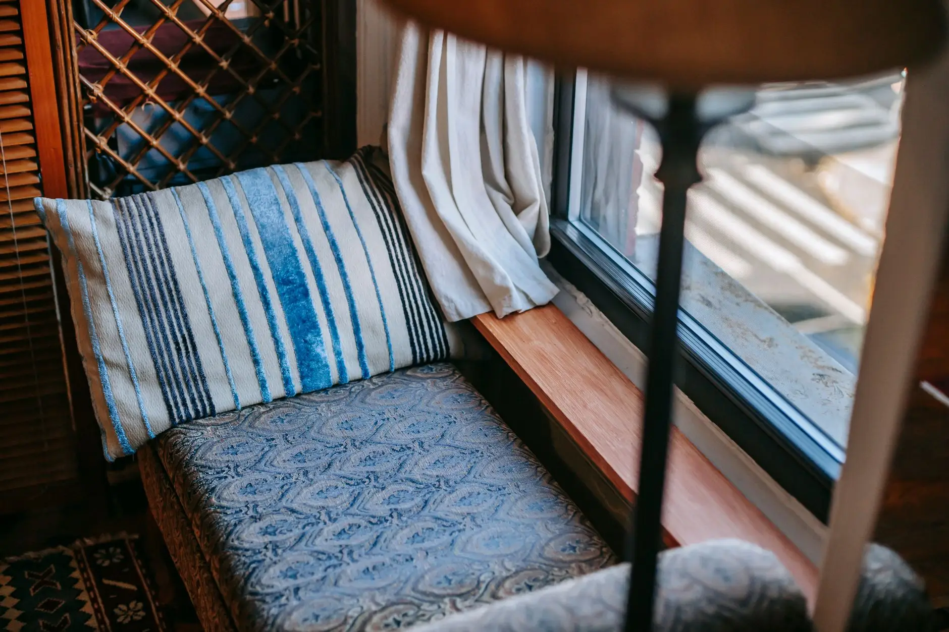 A close-up of a patterned upholstered bench cushion in a kitchen window seat