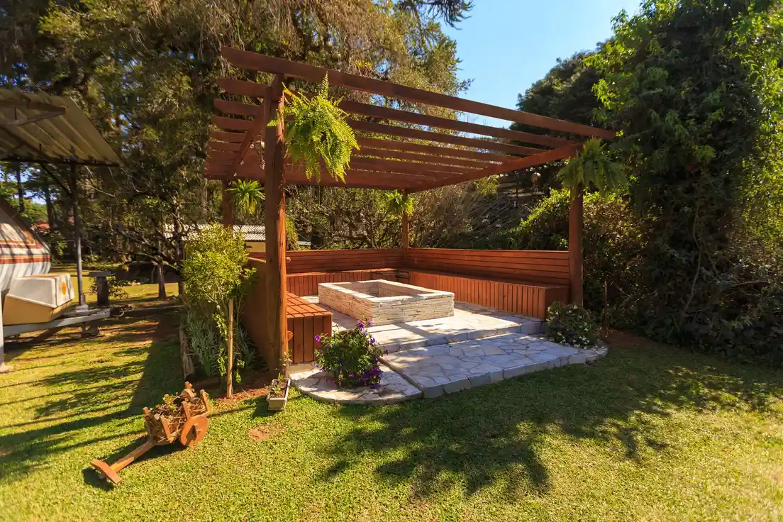 A freestanding wood patio cover pergola standing apart from the house in a backyard