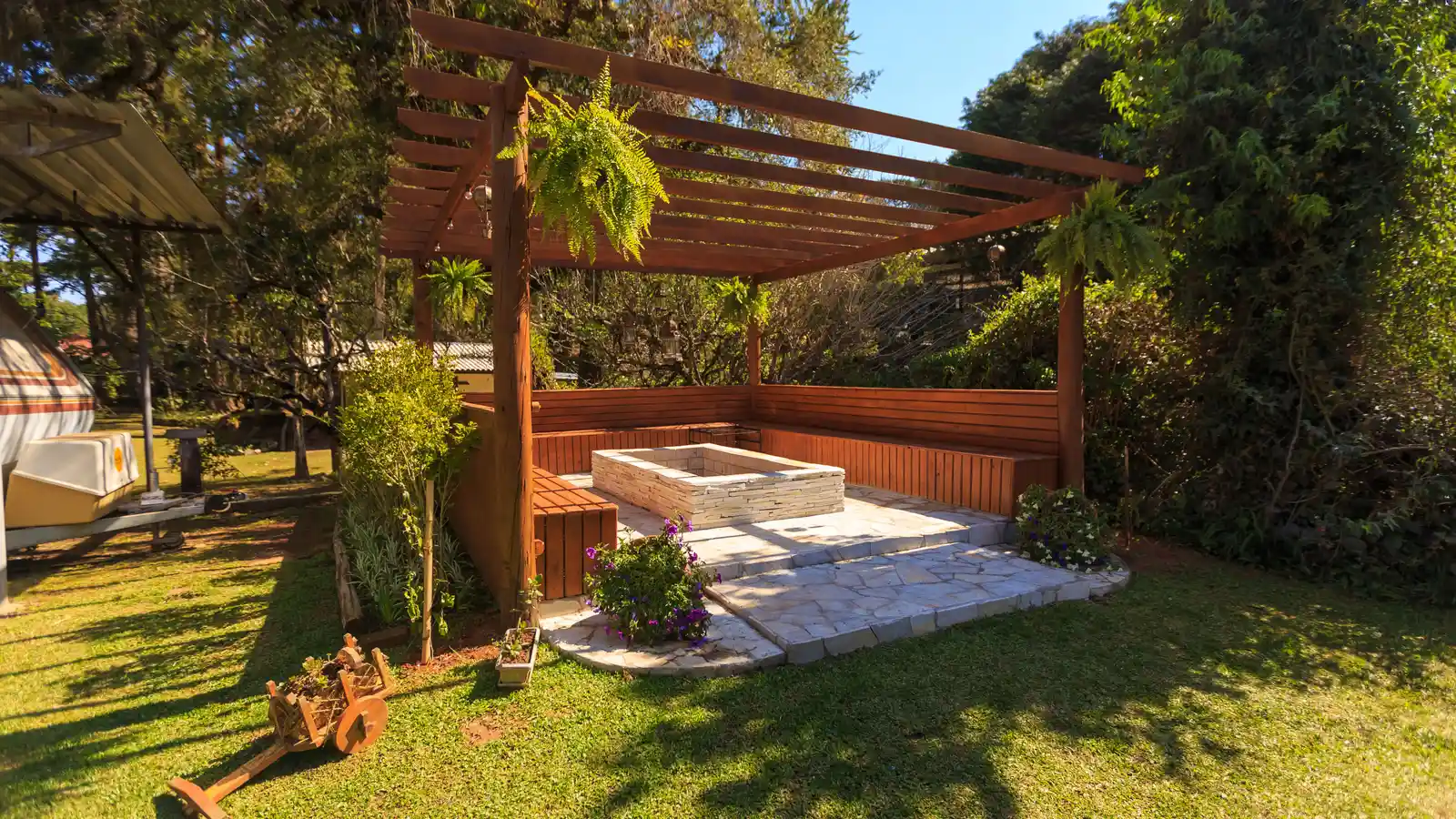 A freestanding wood patio cover pergola standing apart from the house in a backyard