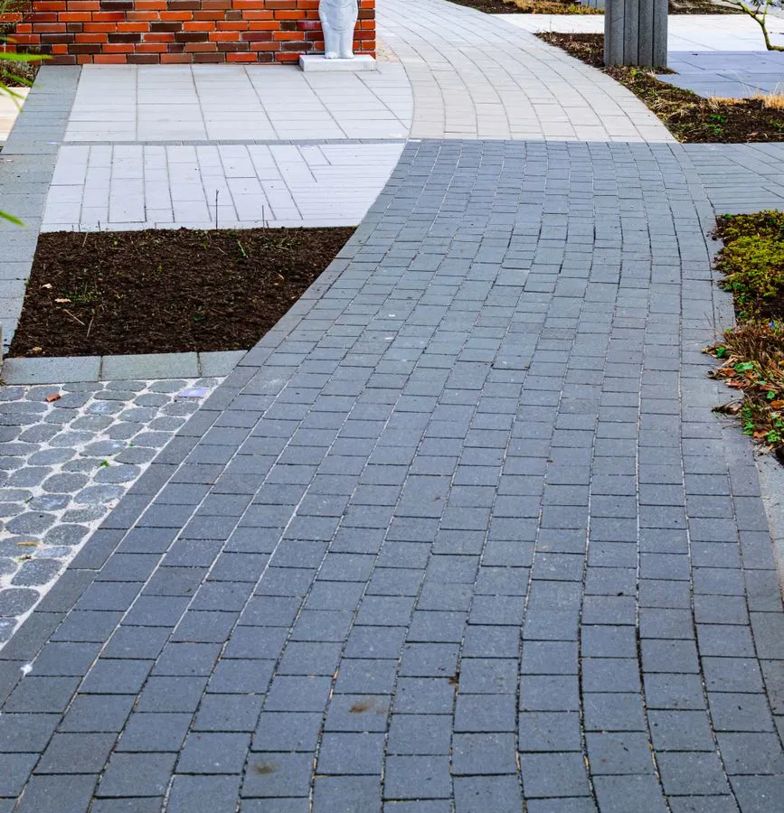 A curved brick paver walkway with a defined brick border edging the path