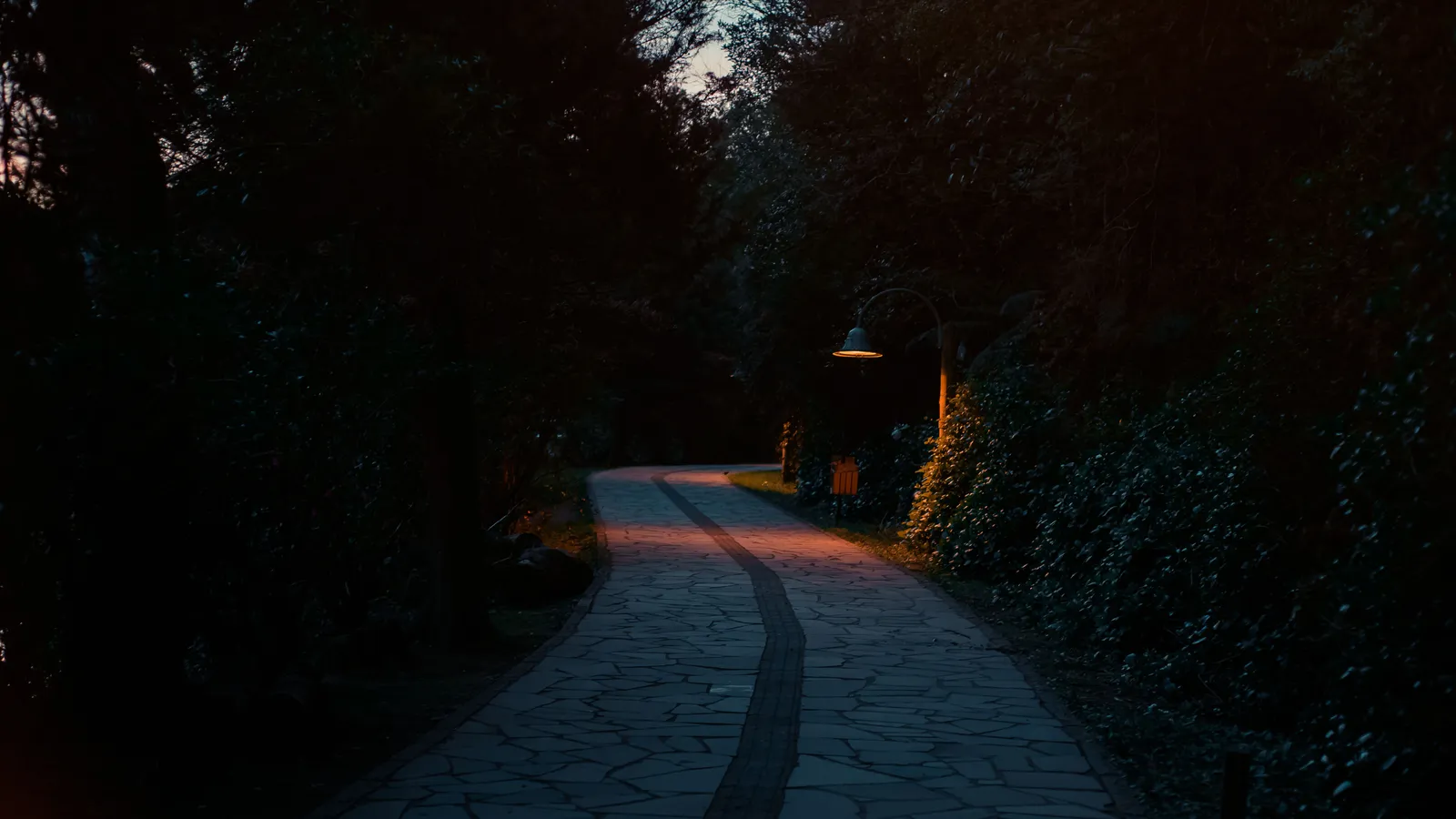 A stone garden walkway lit with warm path lighting at dusk